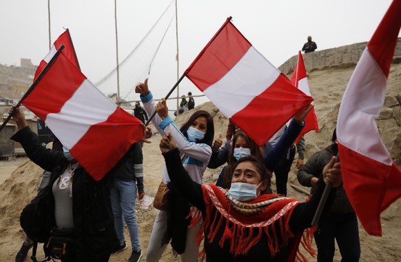 Backers of presidential candidate Keiko Fujimori wave Peruvian flags waiting for her arrival to a breakfast at the San Juan de Lurigancho neighborhood in Lima, Peru, Sunday, June 6, 2021. Peruvians vo ...