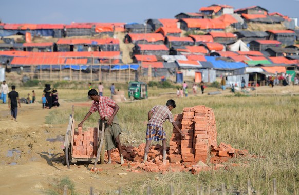 epa06386326 Rohingya men load a trailer with bricks at the Jamtoli refugee camp near Cox&#039;s Bazar, Bangladesh, 12 December 2017 (issued 13 December 2017). More than 646,000 Rohingya refugees have  ...