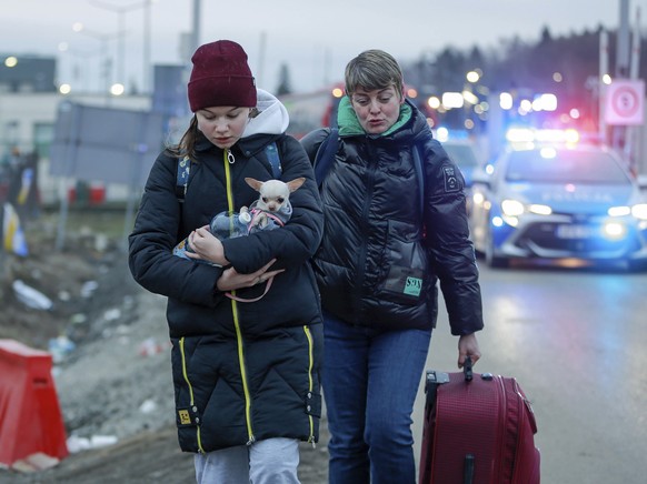 A girl from Ukraine holds a dog as she arrives with another woman to the border crossing in Medyka, southeastern Poland, Wednesday, March 2, 2022. The U.N. refugee agency said Tuesday that about 660,0 ...