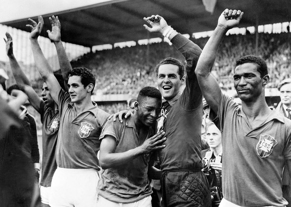 Brazil&#039;s 17- year-old star Pele, center, weeps on the shoulder of goalkeeper Gylmar Dos Santos Neves after Brazil&#039;s 5-2 victory over Sweden in the final of the World Cup tournament in Stockh ...