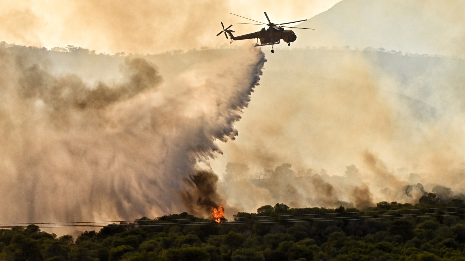 epaselect epa10754387 A firefighting plane drops water to extinguish a forest fire in the area of ​​Aghios Charalambos in Loutraki, Corinth, Greece, July 18, 2023. The fire service has recommended precautionary measures...