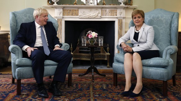 FILE - In this Monday. July 29, 2019 file photo, Scotland&#039;s First Minister Nicola Sturgeon, right, sits with Britain&#039;s Prime Minister Boris Johnson, in Bute House, ahead of their meeting, in ...
