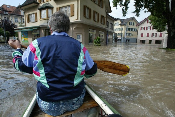 Ein Mann paddelt am Dienstag 23. August 2005 in einem Boot durch das Hochwasser im Zentrum von Sarnen. Der Obwaldner Hauptort stand am Dienstag bis zu einem Meter hoch unter Wasser. (KEYSTONE/Urs Flue ...