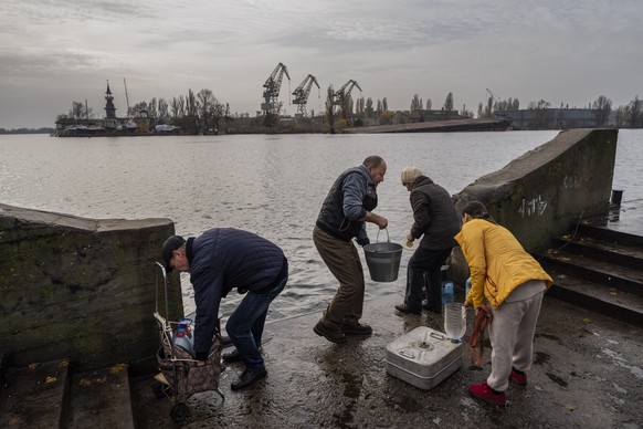 Residents of the recently liberated city of Kherson draw water from the bank of the Dnipro River, near the frontline, southern Ukraine, Monday, Nov. 21, 2022. (AP Photo/Bernat Armangue)