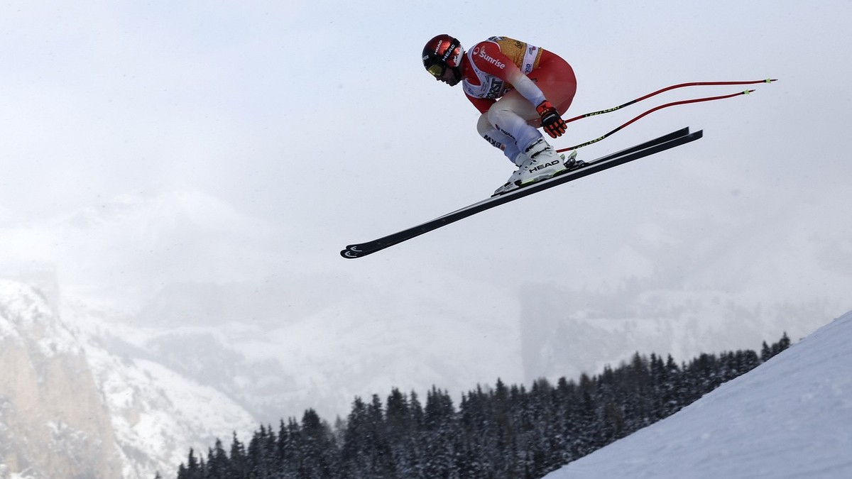 Switzerland's Beat Feuz is airborne during an alpine ski, men's World Cup downhill training, in Val Gardena, Italy, Tuesday, Dec.13, 2022. (AP Photo/Gabriele Facciotti)