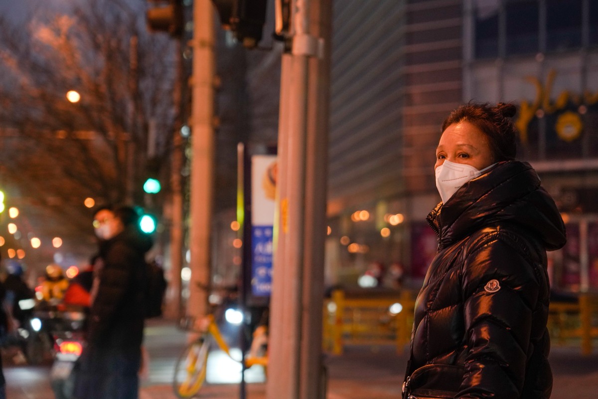 epa10399635 A woman wearing a face mask stands on street in Beijing, China, 11 January 2023. Chinese state media defended on 11 January China's countermeasures against South Korea and Japan over  ...