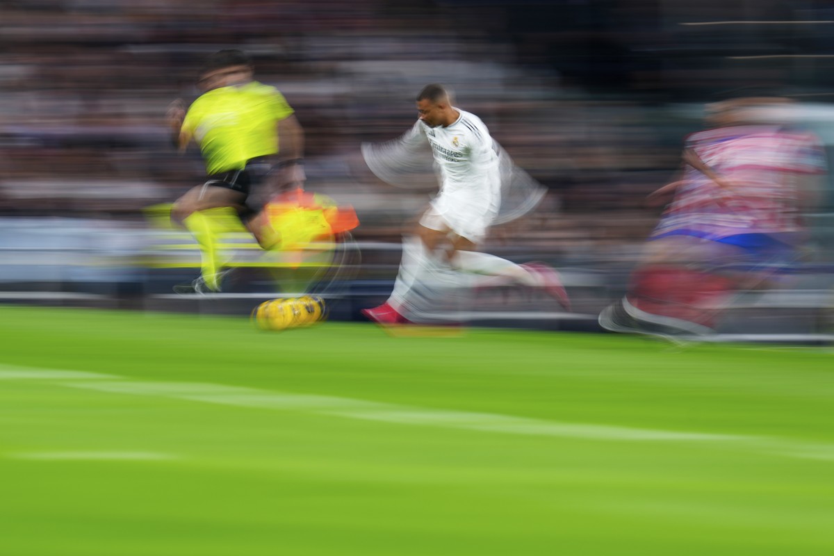 Real Madrid's Kylian Mbappe, center, runs with the ball during a Spanish La Liga soccer match between Real Madrid and Atletico Madrid at the Santiago Bernabeu stadium in Madrid, Saturday, Feb. 8, ...