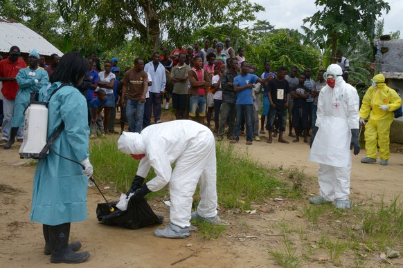 Mitarbeiter des Roten Kreuzes bei Dekontaminationsarbeiten in einem Viertel in der liberianischen Hauptstadt Monrovia.