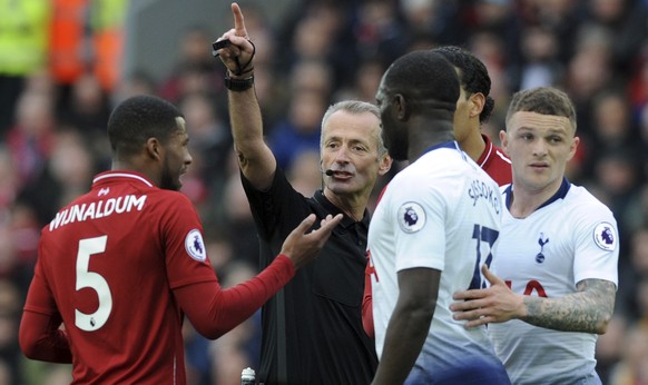 Referee Martin Atkinson, center, discusses with Liverpool&#039;s Georginio Wijnaldum, left, during the English Premier League soccer match between Liverpool and Tottenham Hotspur at Anfield stadium in ...