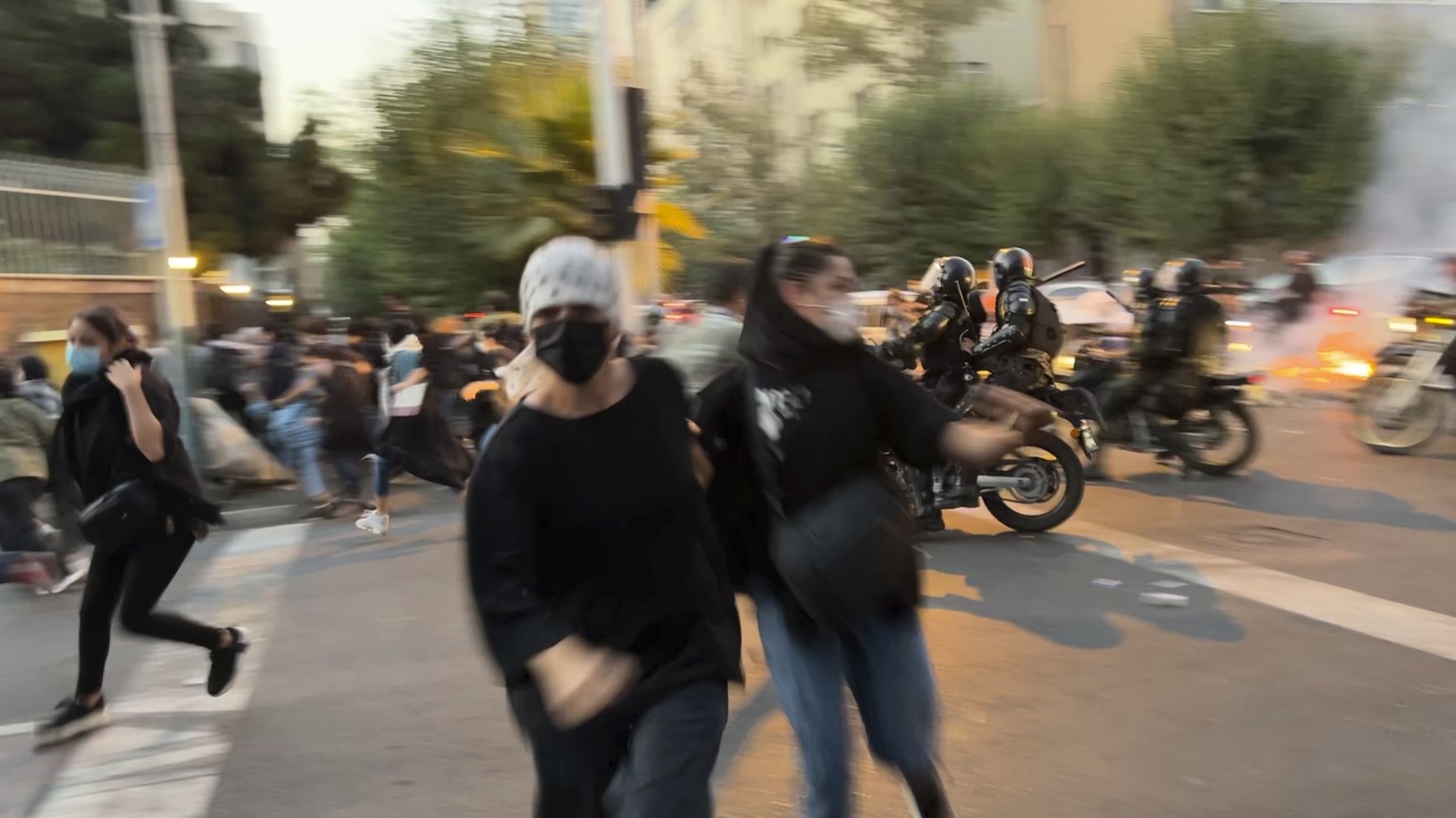 FILE - In this Monday, Sept. 19, 2022, photo taken by an individual not employed by the Associated Press and obtained by the AP outside Iran, women run away from anti-riot police during a protest of t ...