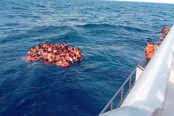 In this photo made from video released by the Indonesian National Search and Rescue Agency (BASARNAS), crew pull survivors from a passenger ferry Putri Yasmin that caught fire while traveling from the ...