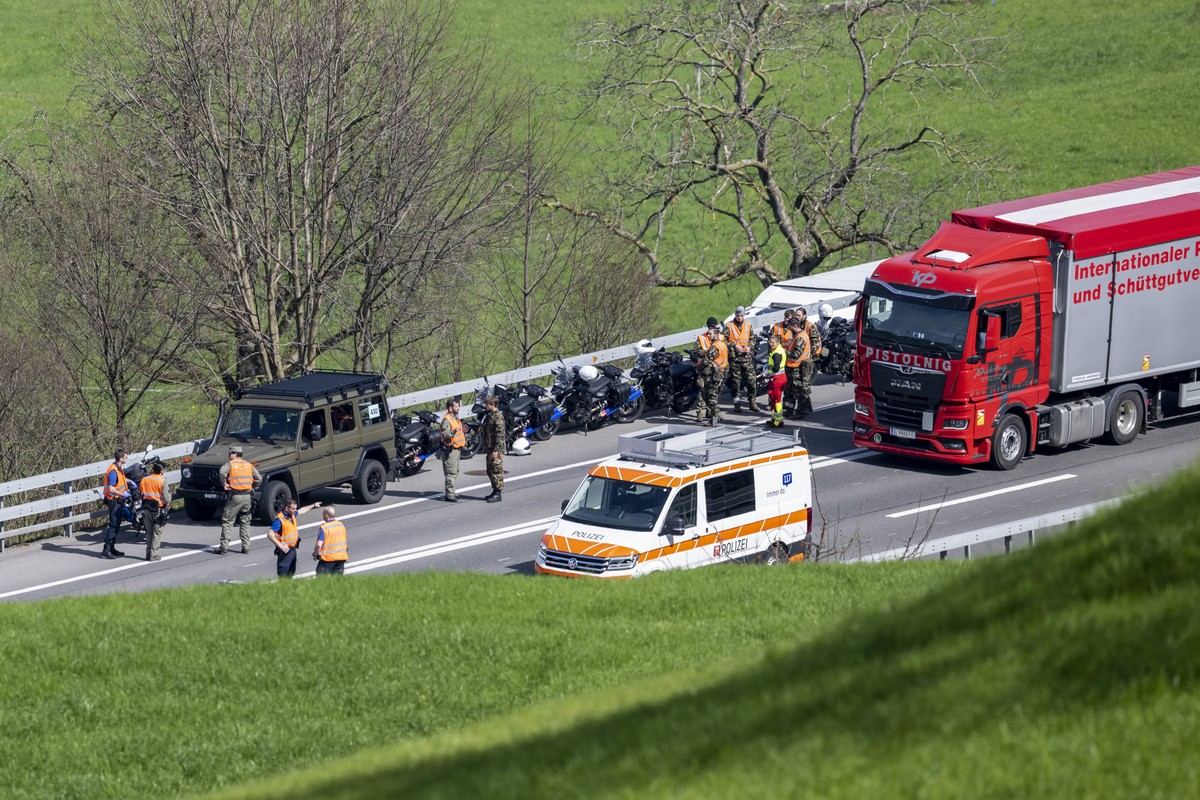 Motorradfahrer der Schweizer Armee sowie Hilfskraefte stehen auf dem Pannenstreifen, nach einem Unfall auf der Autobahn A2 bei Buochs im Kanton Nidwalden am Mittwoch, 20. Maerz 2024. Die Autobahn Rich ...