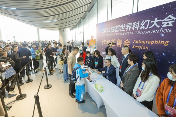 231020 -- CHENGDU, Oct.  August 20, 2023 -- Hugo Award winner Liu Cixin 6th R signs autographs for science fiction enthusiasts during the 81st World Science Fiction Convention WorldCon in Chengdu, southwest China's Sichuan Province.