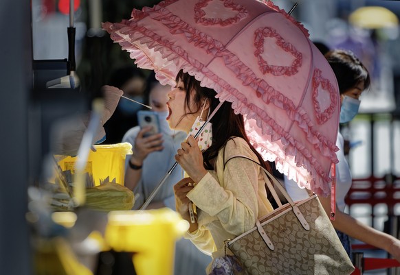 epaselect epa10105383 A woman takes Coronavirus PCR test on the street, in Shanghai, China, 04 August 2022. Shanghai continues PCR mass testing to control community transmission of COVID-19. Shanghai  ...