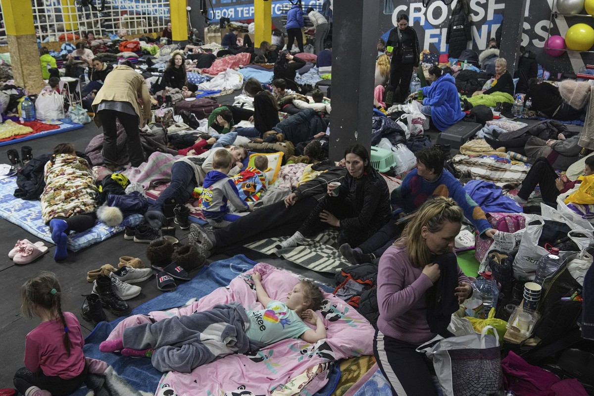 People sit and lie on the floor in the improvised bomb shelter in a sports center, which can accommodate up to 2000 people, in Mariupol, Ukraine, late Sunday, Feb. 27, 2022. Explosions and gunfire tha ...