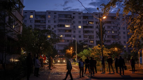 Local residents walk on a street with pieces of broken glass at the site of a residential building that was damaged after a Russian attack in Kyiv, Ukraine, Saturday, May 24, 2025. (AP Photo/Alex Babe ...