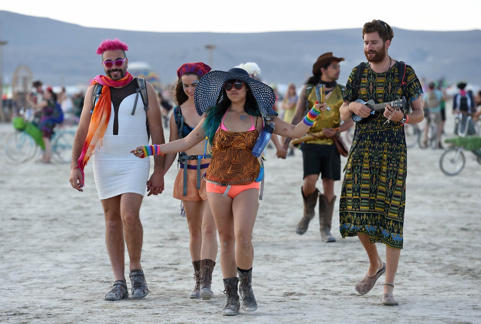 In this Monday, Aug. 25, 2014 photo, Burning Man participants walk on the playa at the annual Burning Man event in the Black Rock Desert of Gerlach, Nev. (AP Photo/Reno Gazette-Journal, Andy Barron)