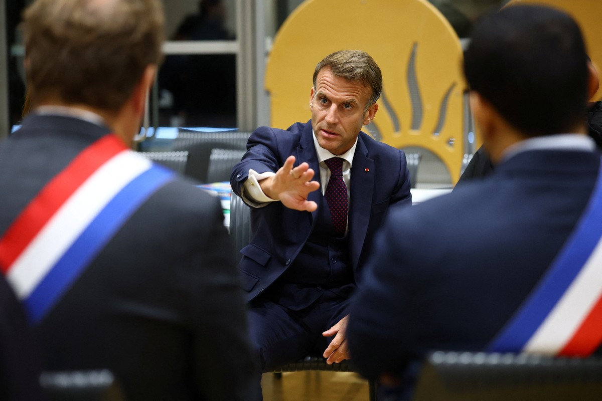 epa13325941 French President Emmanuel Macron (C) speaks with community members at the town hall in Trappes, near Paris, France, 23 October 2026. The visit follows a drive-by shooting that killed one p ...