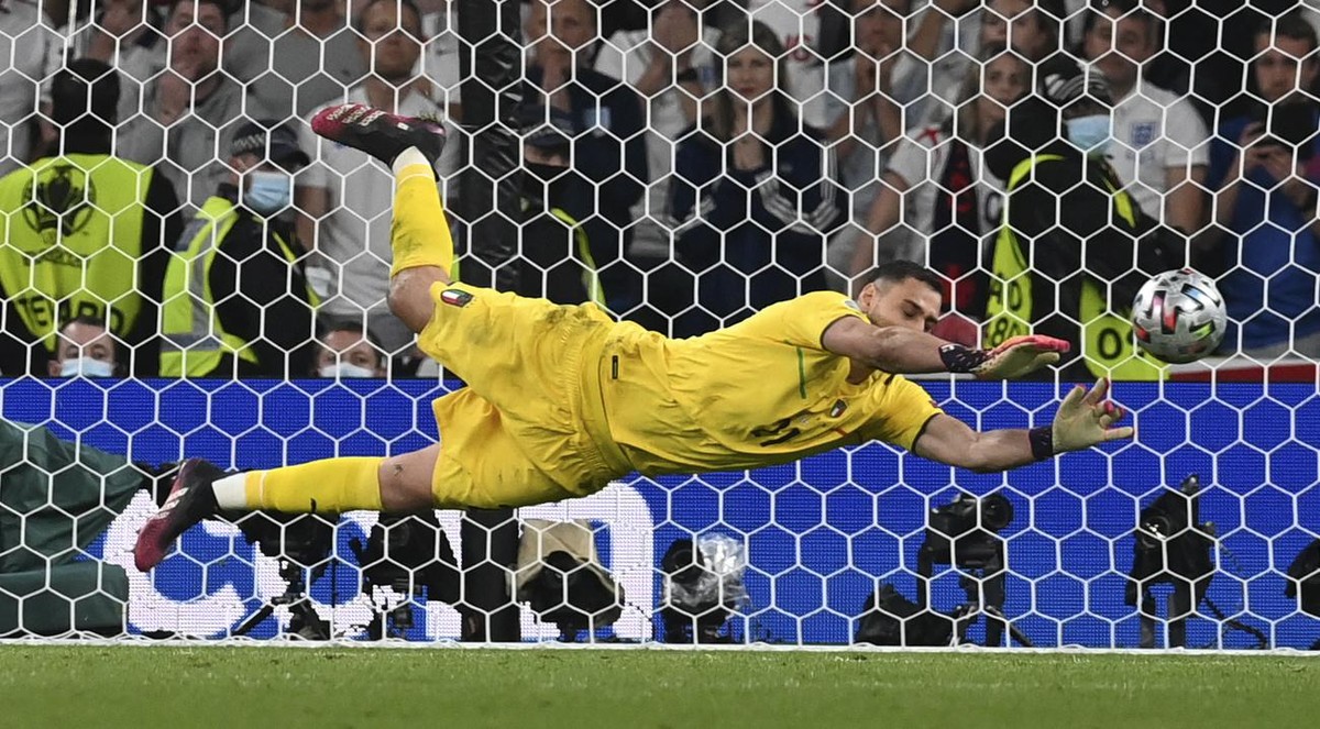 Italy's goalkeeper Gianluigi Donnarumma makes a save against England's Jadon Sancho during penalty shootout of the Euro 2020 soccer championship final match between England and Italy at Wemb ...