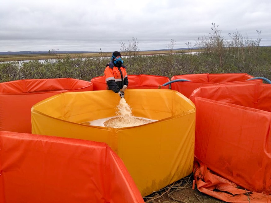 In this handout photo provided by the Russian Marine Rescue Service, a rescuer works collecting oil contaminated water from an oil spill outside Norilsk, 2,900 kilometers (1,800 miles) northeast of Mo ...