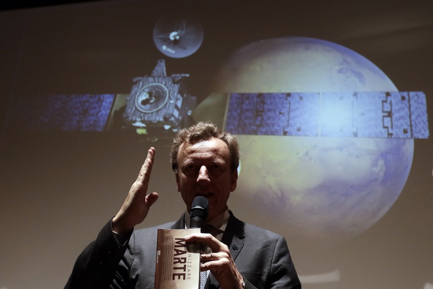 Italian Space Agency President Roberto Battiston talks to journalists in front of a rendering of the Schiaparelli Space Module and of the planet Mars is displayed on a movie screen, during an event on ...