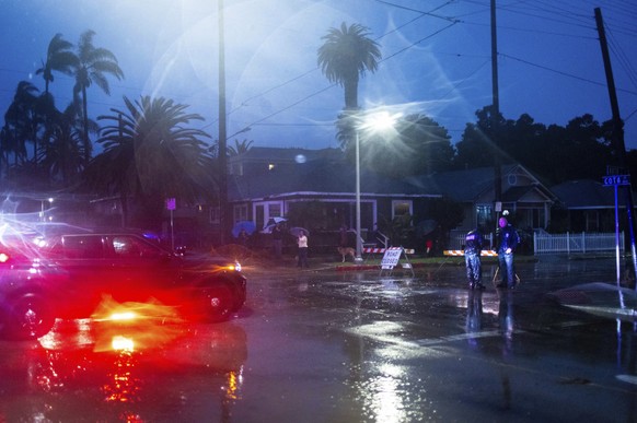 Police officers inform residents of increasing flooding during a rainstorm, Sunday, Feb. 4, 2024, in Santa Barbara, California.  (AP Photo/Ethan Swope)