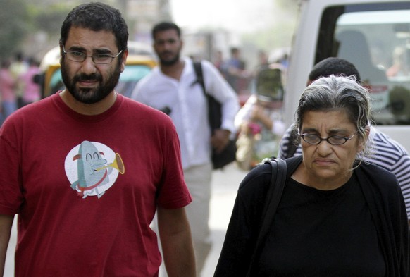 FILE - Alaa Abdel Fattah, left, a leading Egyptian pro-democracy activist walks with his mother Laila Soueif, a university professor who is an also an activist, outside a court, in Cairo, Egypt, Oct.  ...