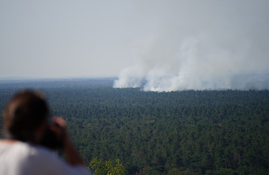 epa10105287 Smoke rises during a forest fire at the Grunewald in Berlin, Germany, 04 August 2022. The Berlin Fire Department reported on their twitter channel about a currently ongoing fire in Grunewa ...