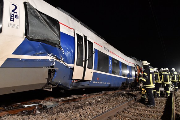 epa06370122 Rescue workers inspect a passenger train, that collided with a freight train in Meerbusch, Germany, 05 December 2017. According to reports about 50 people have been injured in the crash. E ...