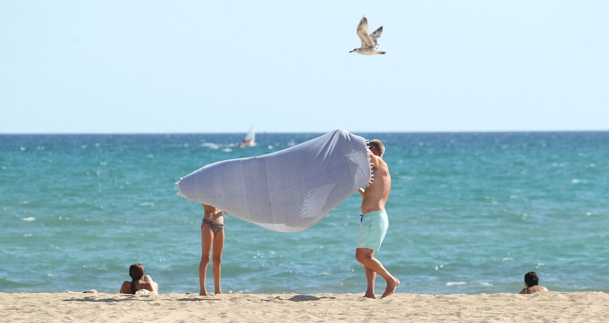 Ein Mann und eine Frau stehen bei Temperaturen über 35 Grad am Strand von Playa de Palma. Mallorca Spanien *** A man and a woman stand on the beach of Playa de Palma Mallorca Spain in temperatures abo ...