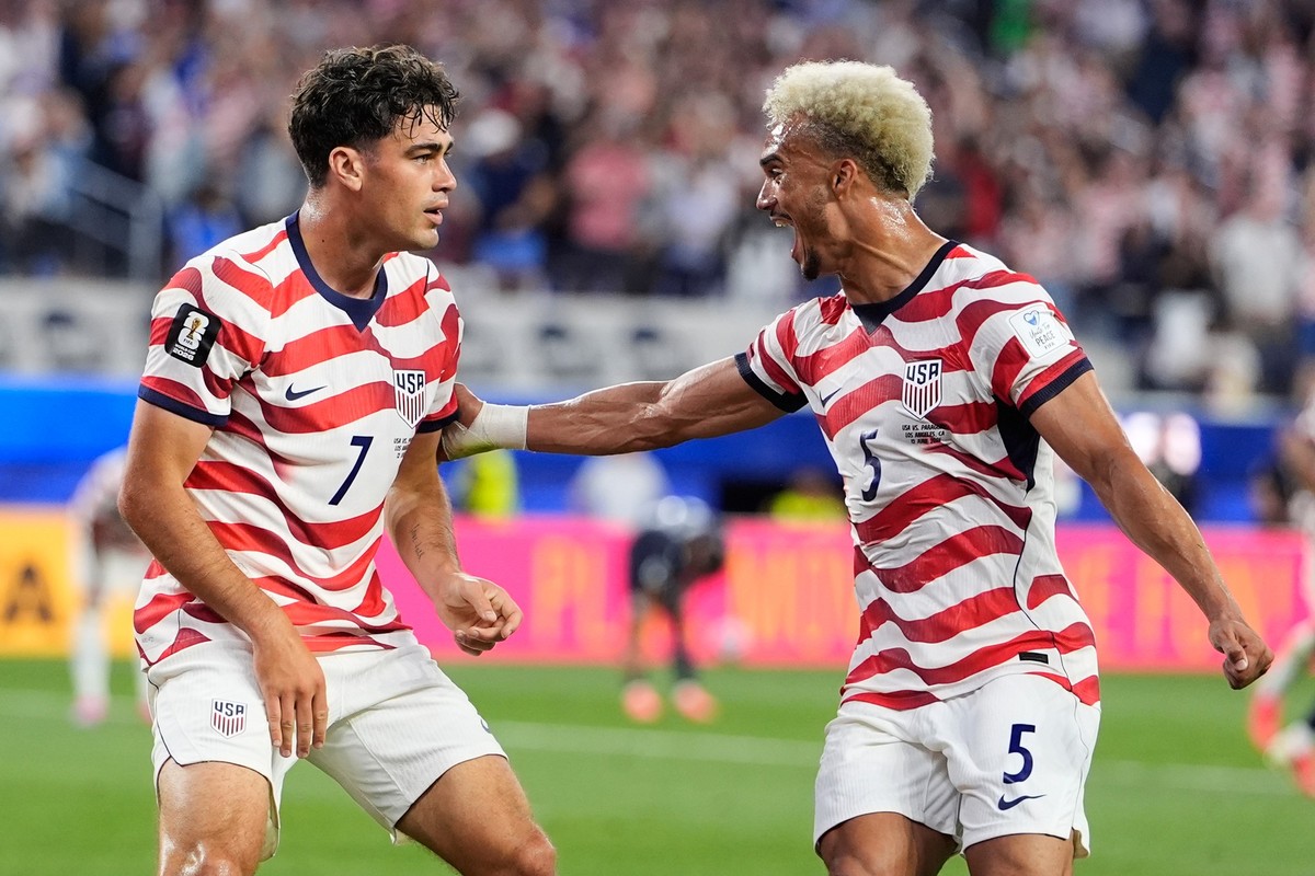 United States' Giovanni Reyna, left, celebrates with teammate Antonee Robinson after scoring his team's fourth goal during the World Cup Group D soccer match between the United States and Pa ...