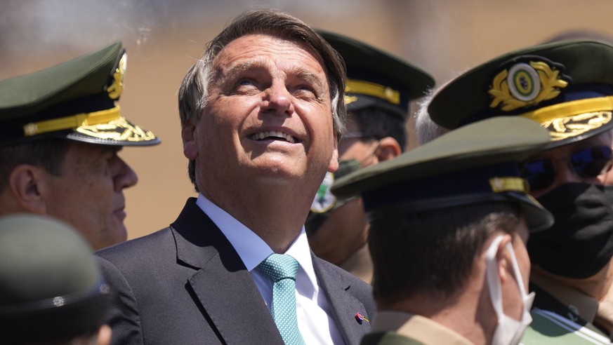 Brazilian President Jair Bolsonaro looks up at parachute jumpers during a ceremony marking Soldier Day at Army headquarters in Brasilia, Brazil, Wednesday, Aug. 25, 2021. (AP Photo/Eraldo Peres)
Jair  ...