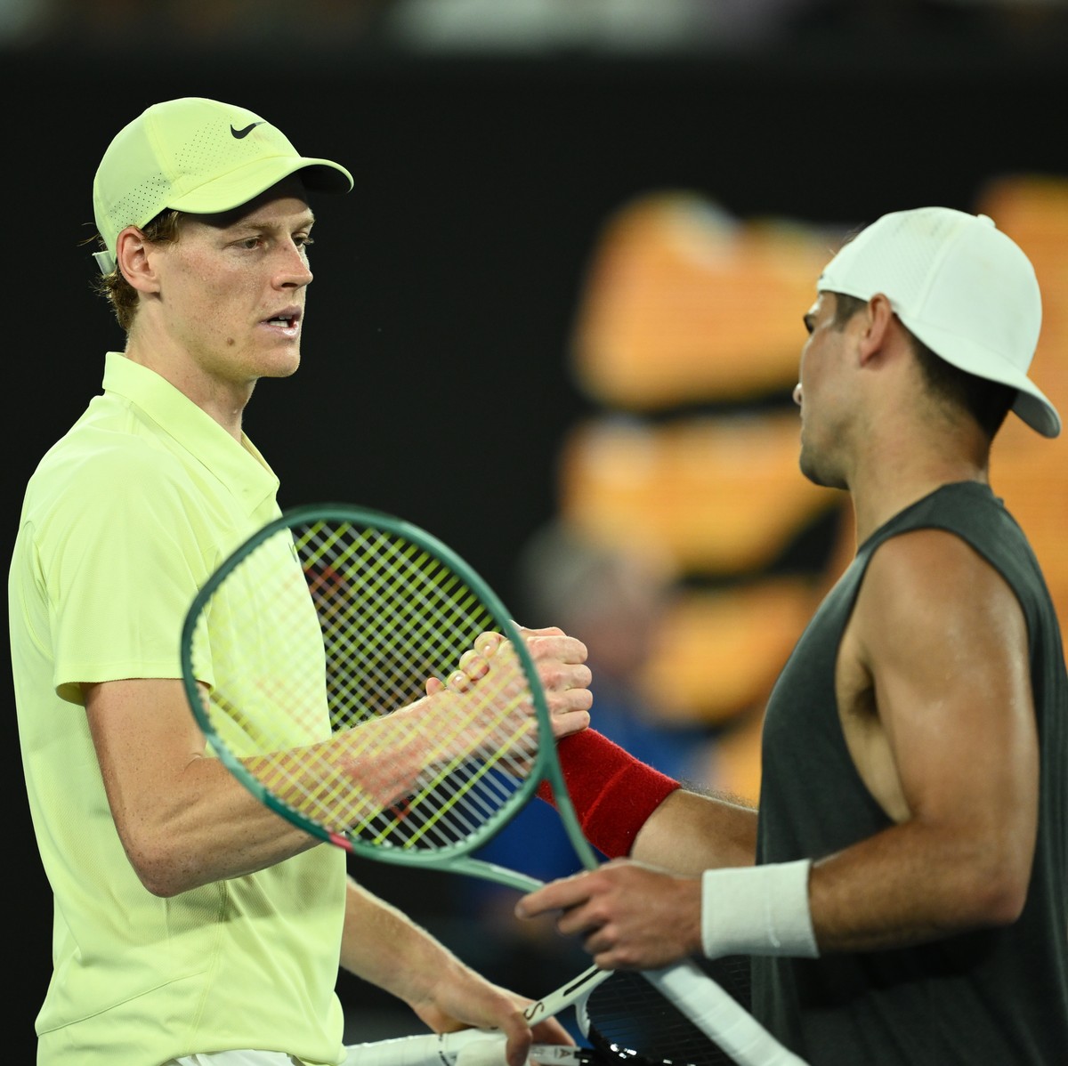 epa11833124 Jannik Sinner (L) of Italy celebrates winning his Men's Singles round 3 match against Marcos Giron (R) of USA at the Australian Open tennis tournament in Melbourne, Australia, 18 Janu ...