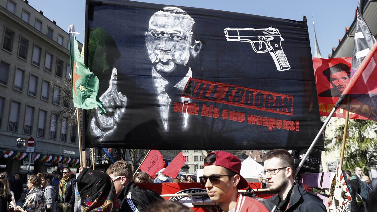 epa05870523 A banner reads; 'Kill Erdogan with his own weapons', as protesters march during a demonstration against the Turkish President Recep Tayyip Erdogan, in Bern, Switzerland, 25 March ...