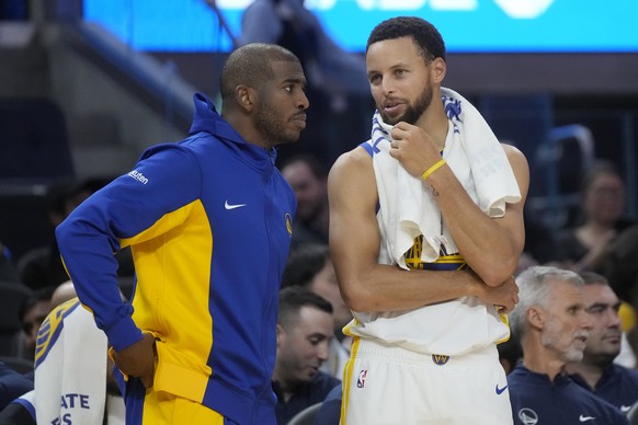 Golden State Warriors guard Chris Paul, left, talks with guard Stephen Curry during the second half of an NBA preseason basketball game against the San Antonio Spurs in San Francisco, Friday, Oct. 20, ...