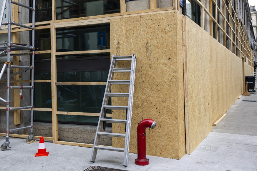 Des planches de bois sont posees devant les vitrines d'un etablissement pour le proteger d'eventuelles degradations de la part de manifestants durant la manifestation NoG7 liee au sommet du  ...