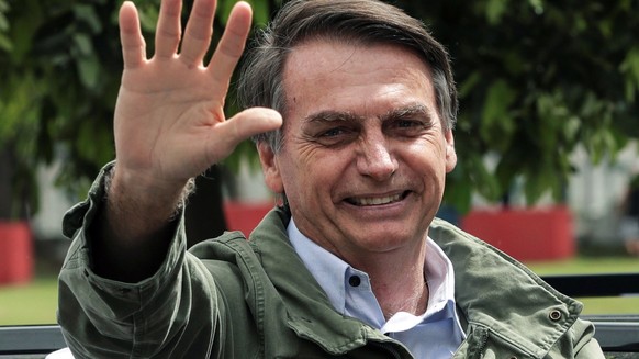 epa07127076 Brazilian far-right presidential candidate Jair Bolsonaro greets supporters after voting, in Rio de Janeiro, Brazil, 28 October 2018. Around 147 millions Brazilians are called to vote in t ...
