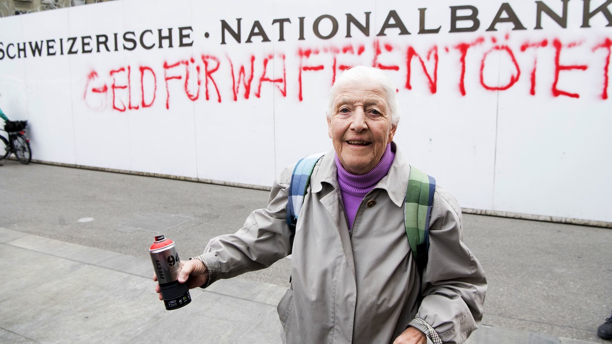 86-year-old activist Louise Schneider poses for media after spraying the words "Money for Weapons Kills" (in German "Geld Fuer Waffen toetet") on a wall of the Swiss National Bank  ...