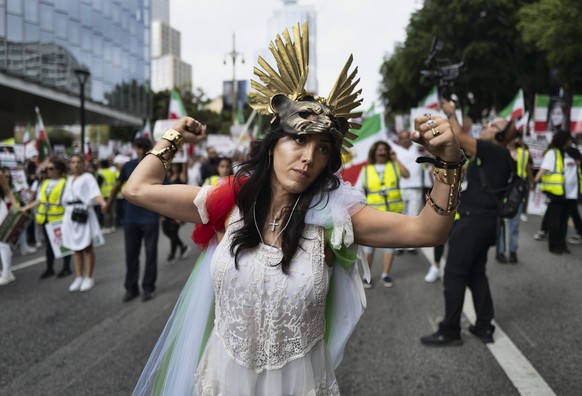 A demonstrator flexes her muscles during a protest against the Iranian regime, in Los Angeles, on Saturday, Oct. 22, 2022, following the death of Mahsa Amini in the custody of the Islamic republic's n ...