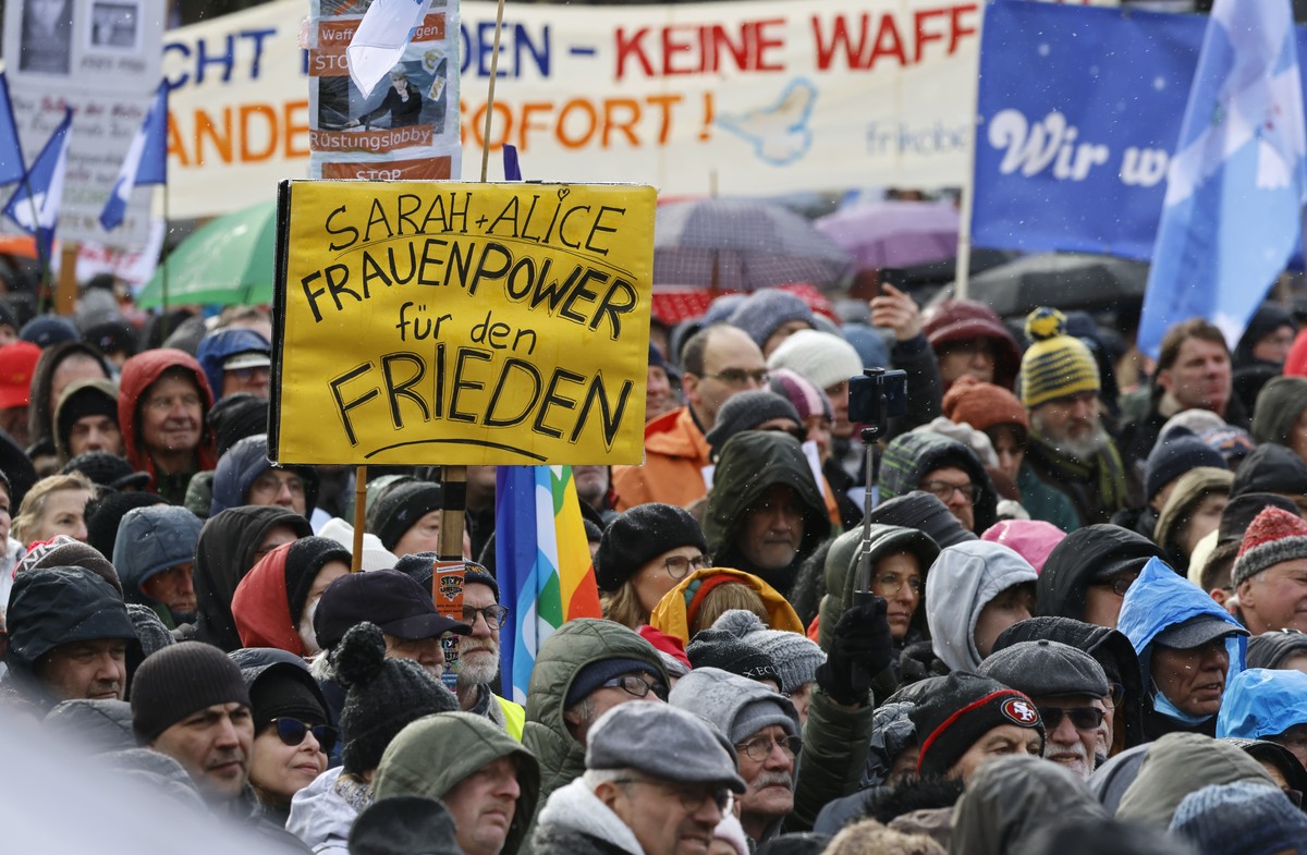 epa10490237 People attends the demonstration 'Uprising for Peace' in front of the Brandenburg gate in Berlin, Germany, 25 February 2023. Words read: 'Sarah + Alice Women's Power fo ...