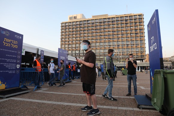 epa08912560 People wait in a line to receive COVID-19 vaccine outside the new Tel Aviv municipality vaccines center in Rabin square, Tel Aviv, Israel, 31 December 2020. Media report that Israel is on  ...