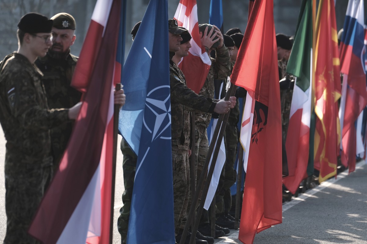epa12811119 Soldiers hold NATO and national flags during the visit of the Czech president, Petr Pavel (not pictured), to the Adazi Military Base, Latvia, 11 March 2026. Czech President Petr Pavel visi ...
