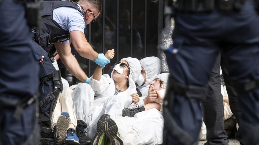 epa07703252 Police officers arrest activists from the Collective Climate Justice who were blocking the entrance to the Swiss bank Credit Suisse on Paradeplatz in Zurich, Switzerland, 08 July 2019. The ...