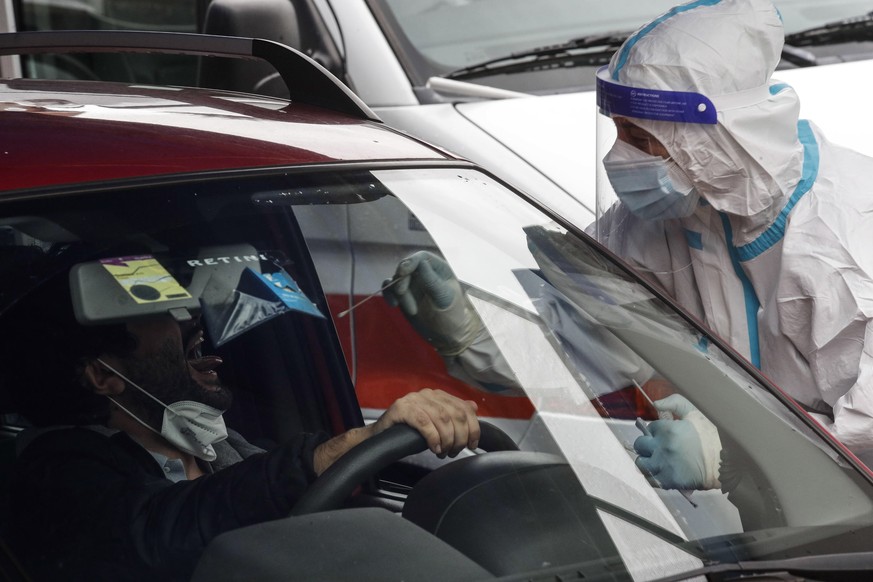 epa08726592 A health worker wearing protective equipment takes swabs for coronavirus tests at the &#039;Casa della Salute&#039; of the ASL Roma 1 health facilities in the Labaro district, in Rome, Ita ...