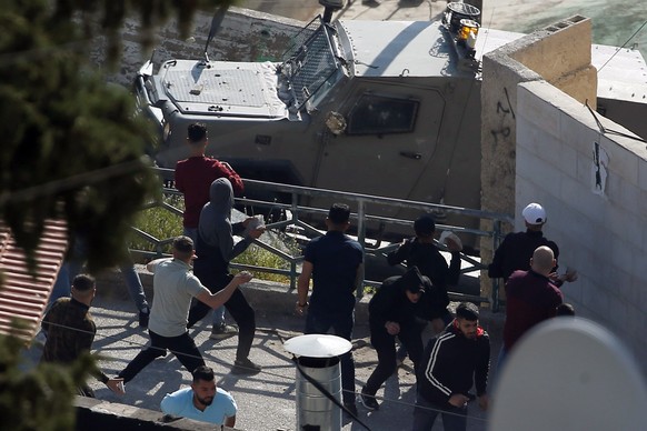 epa10616601 Palestinians throw stones at Israeli forces during a raid in the old city of Nablus, 09 May 2023. According to the Israeli military, Israeli troops arrested two Palestinians and injured se ...