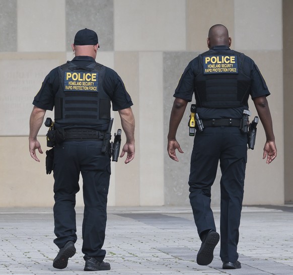 epa10686789 Police officers on the grounds of the Wilkie D. Ferguson United States Courthouse, where former US President Donald Trump is scheduled to surrender to federal authorities on 13 June, in Mi ...