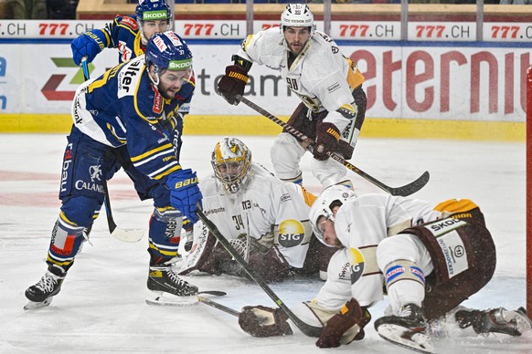 Der Davoser Julian Schmutz bei seinem Treffer zur 2:1 Fuehrung gegen die Genfer Torhueter Gauthier Descloux, Simon Le Coultre und Sandis Smons, vl., im Eishockey-Qualifikationsspiel der National Leagu ...