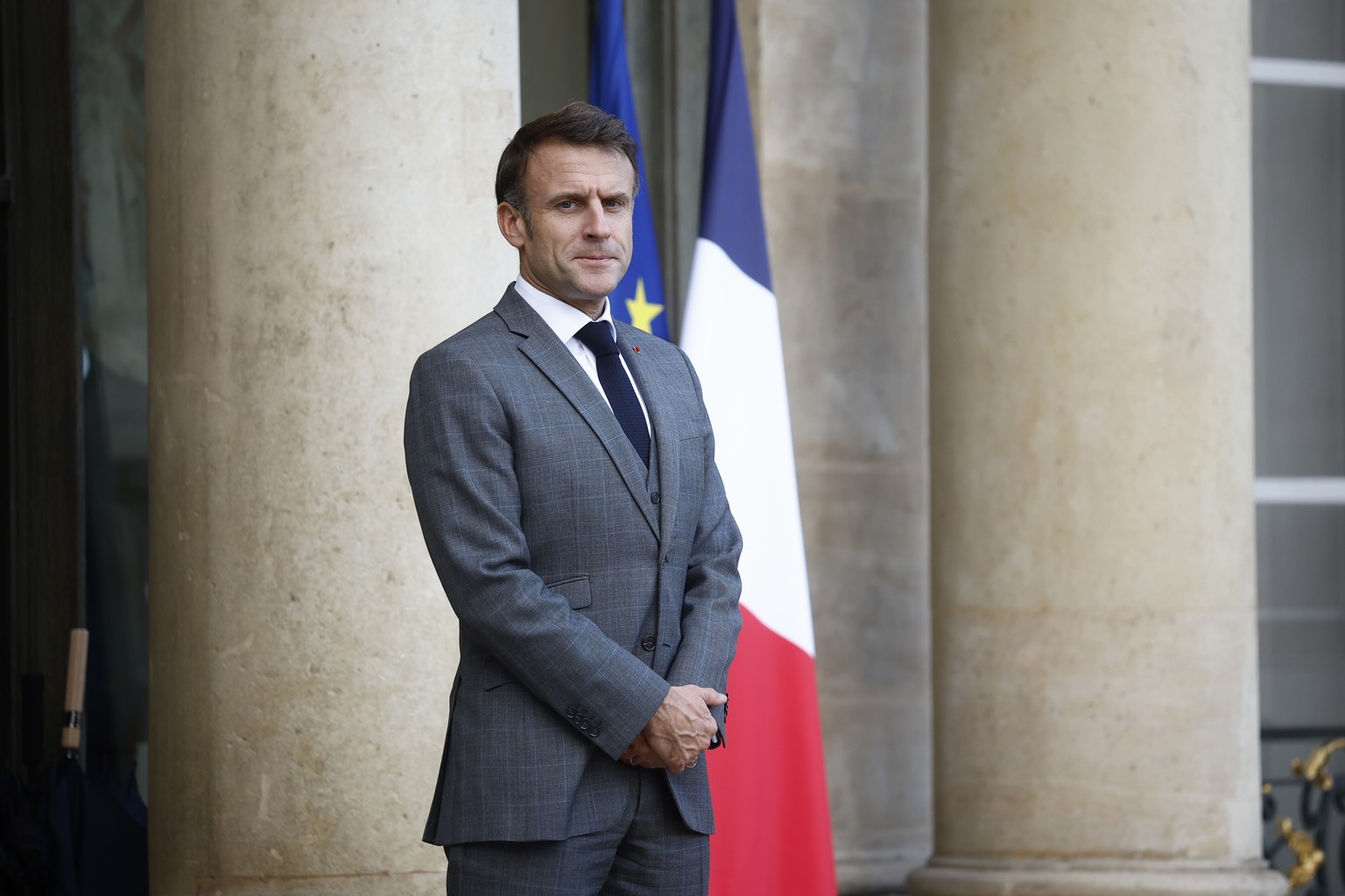 epa10966378 French President Emmanuel Macron stands outside the Elysee Palace to welcome Montenegro President Jakov Milatovic (not pictured) as part as the 6th edition of the Peace Forum in Paris, Fra ...
