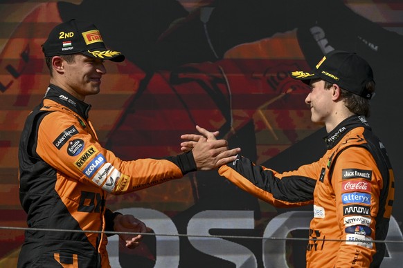 epa11490435 Winner McLaren driver Oscar Piastri of Australia (R) and his second placed British teammate, Lando Norris celebrate on the podium after the Formula One Hungarian Grand Prix at the Hungaror ...