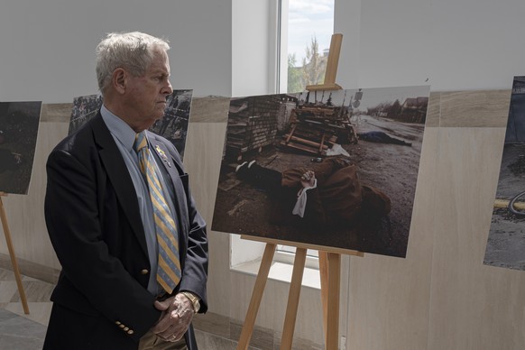 Chairman of the U.S. Helsinki Commission Joe Wilson looks at an exhibition of pictures showing Russian aggression in Bucha, Ukraine, Friday, May 5, 2023. (AP photo/Andrew Kravchenko)
